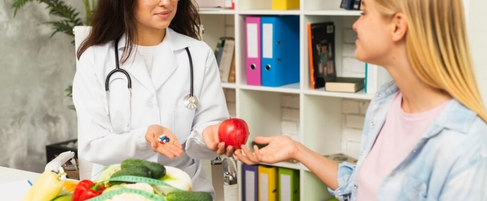 medium-shot-doctor-patient-with-fruits_23-2148302116